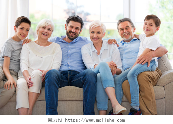 一家人拍摄全家福微笑着坐在沙发上的家庭